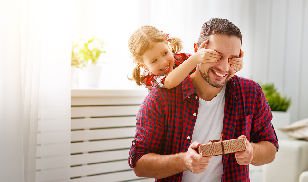 Father's day. Happy family daughter hugging dad and laughs on holiday