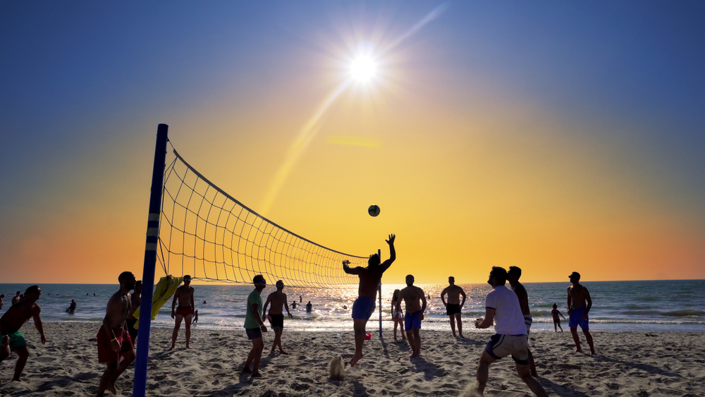 Silhouettes of young men playing volleyball on Varkala beach