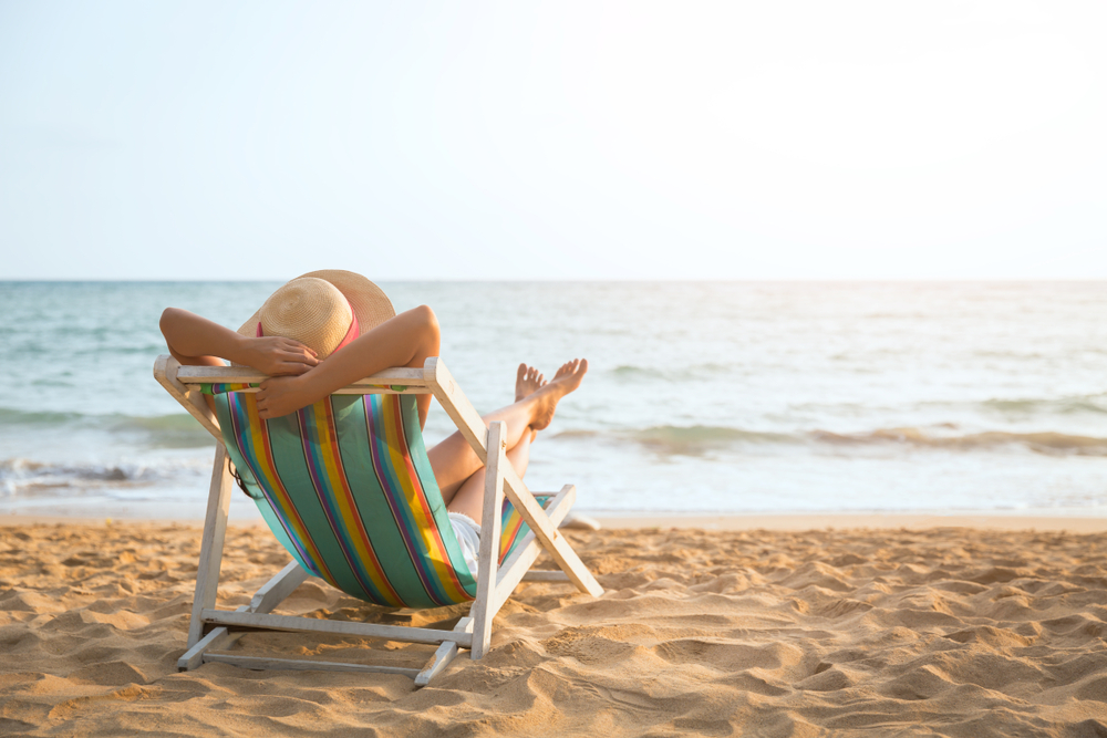 woman with hat relaxing and arm up on chair