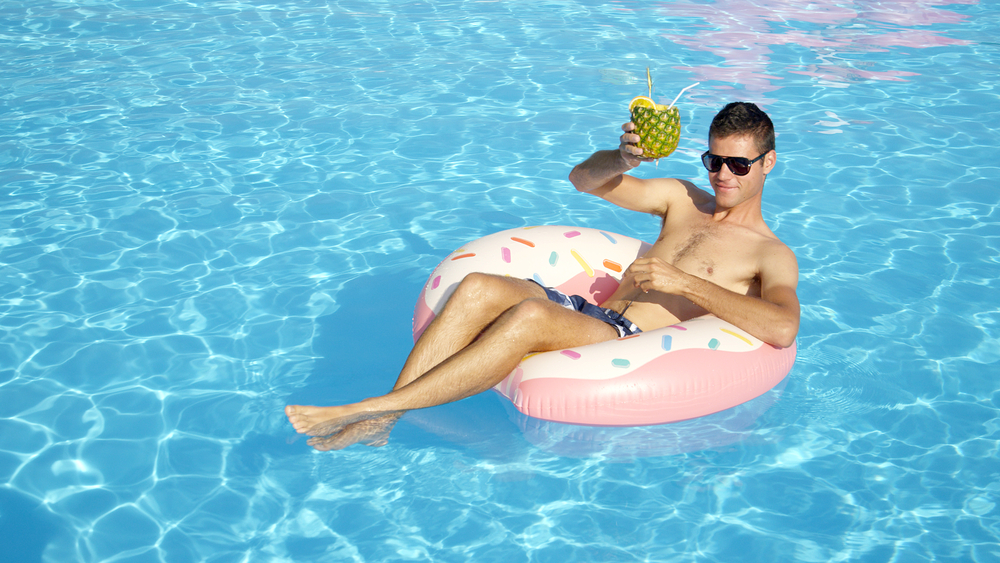 man in pool with drink